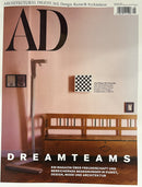 Architectural Digest Germany Magazine cover featuring a pink interior with a wooden bench framed artwork and bold Dreamteams headline for design Magazines
