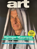 Art (German) Magazine cover featuring a portrait of Maurizio Cattelan under draped fabric with bold white art lettering and colorful German cover lines