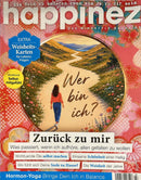 Happinez Magazine cover featuring a woman walking along a winding path through a colorful flower filled landscape with German headlines and wellness themes