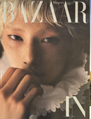 Harper's Bazaar Korea Magazine cover featuring a close up portrait of a model with tousled hair and a dramatic white ruffled collar in warm light