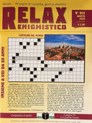 Relax Enigmistico Magazine cover featuring a yellow crossword puzzle design with bold red lettering and a scenic coastal city photograph on the front cover