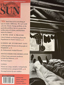 The Sun Magazine cover featuring personal stories and essays beside a black and white photograph of a person relaxing in a rustic cabin bedroom Magazines