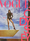 Vogue Korea Magazine cover featuring a model in black fashion standing on a gold platform against a cloudy sky with bold pink typography